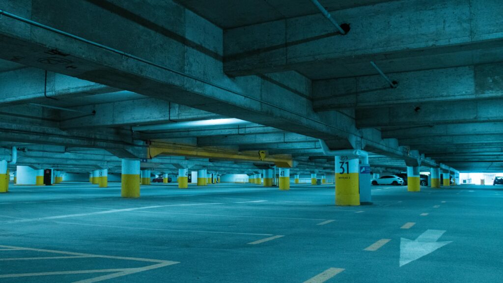 A concrete underground parking garage with empty spaces and marked lines.